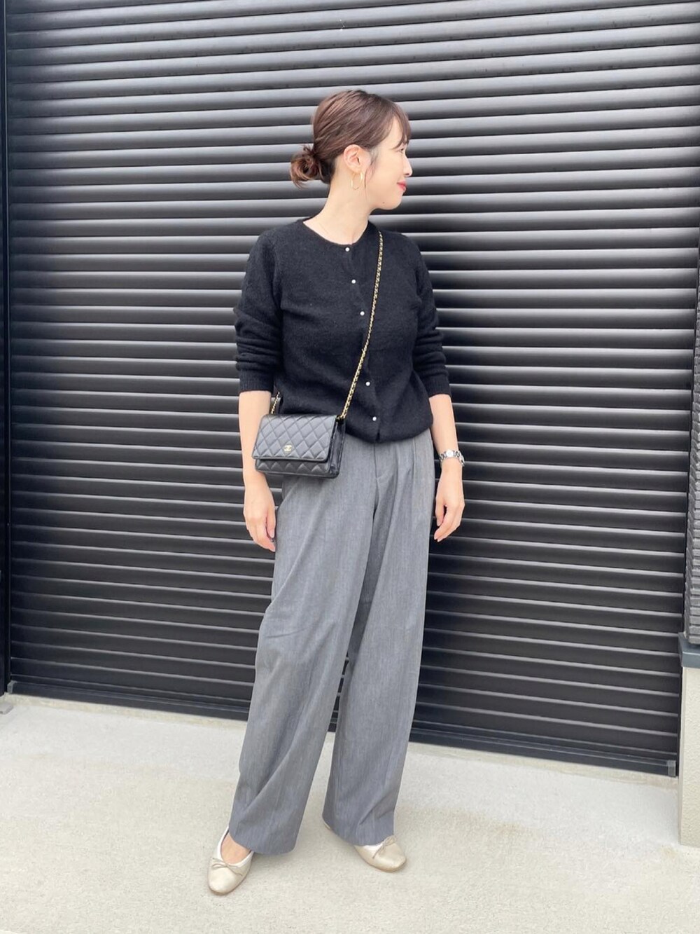 ブラック系のパンツ、ブラック系のニット/セーター、ホワイト系のバレエシューズを着用したレディースの秋コーディネートの2枚目の写真