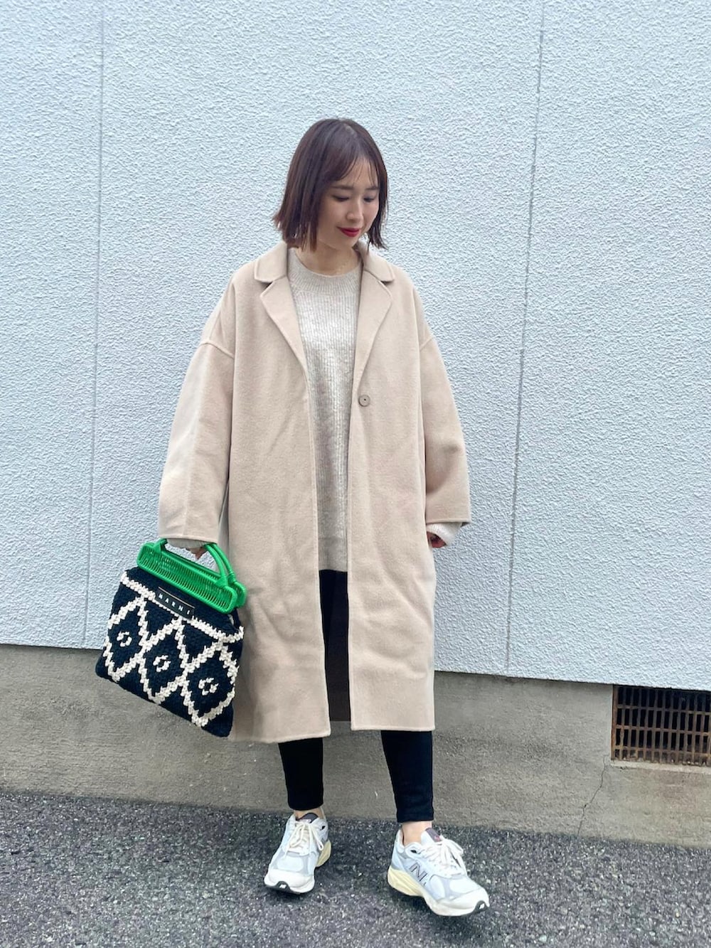 ベージュ系のその他アウター、ホワイト系のスニーカー、グリーン系のバッグを着用したレディースの冬コーディネートの2枚目の写真