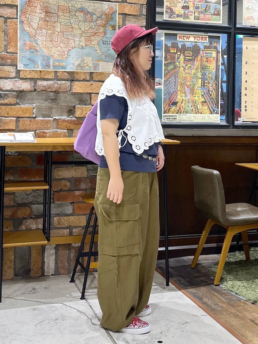 パープル系のトートバッグ、ホワイト系のベスト、ブルー系のTシャツ/カットソーを着用したレディースの夏コーディネートの6枚目の写真