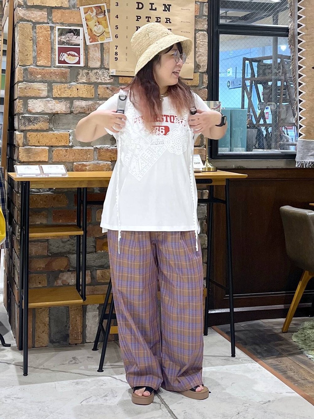 ブラック系のサンダル、ホワイト系のTシャツ/カットソー、グレー系のバックパック/リュックを着用したレディースの夏コーディネートの6枚目の写真