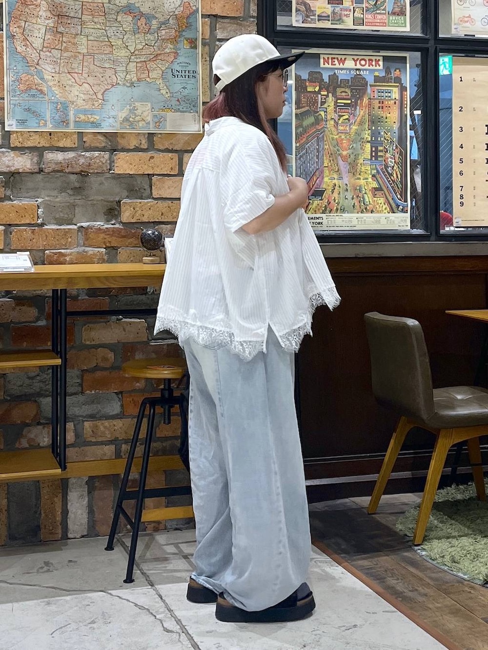 ブルー系のデニムパンツ、ブラック系のサンダル、ブラック系のバックパック/リュックを着用したレディースの夏コーディネートの5枚目の写真