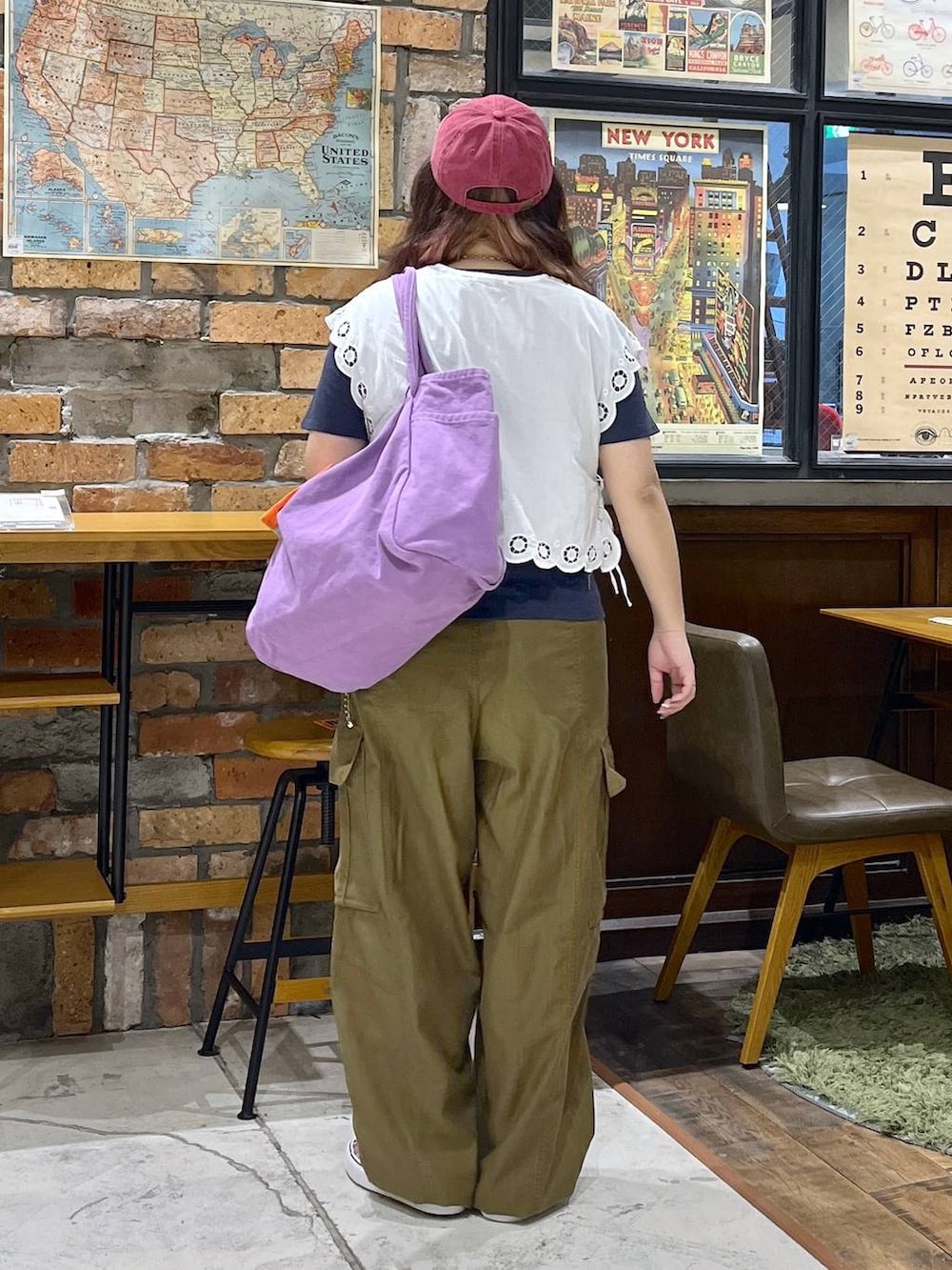 パープル系のトートバッグ、ホワイト系のベスト、ブルー系のTシャツ/カットソーを着用したレディースの夏コーディネートの5枚目の写真