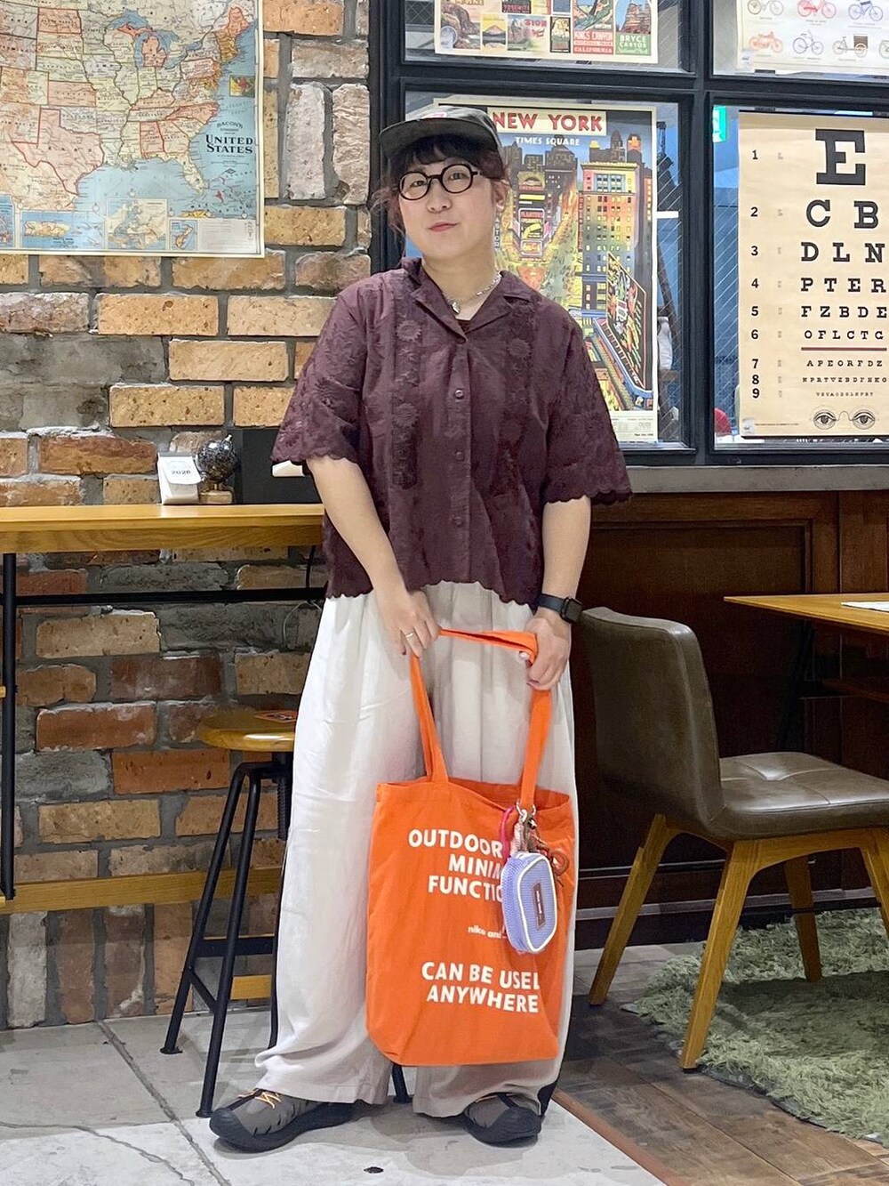 ブラウン系のその他パンツ、ブラウン系のシャツ/ブラウス、レッド系のトートバッグを着用したレディースの夏コーディネートの6枚目の写真