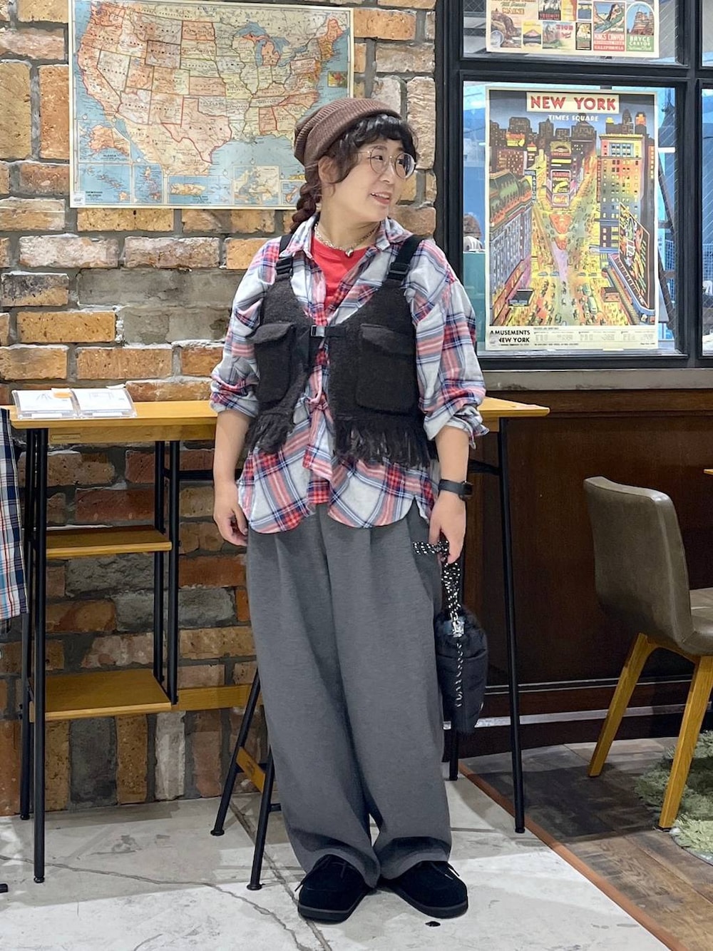 ブラウン系のベスト、レッド系のTシャツ/カットソー、ブラック系のモカシン/デッキシューズを着用したレディースの秋コーディネートの7枚目の写真