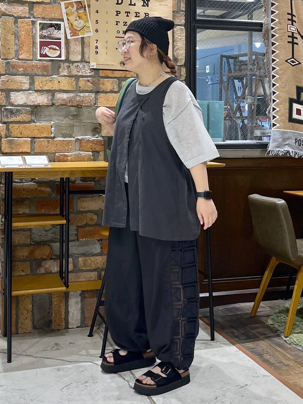 ブラック系のベスト、ブラック系のその他パンツ、ブラック系のサンダルを着用したレディースの夏コーディネートの4枚目の写真