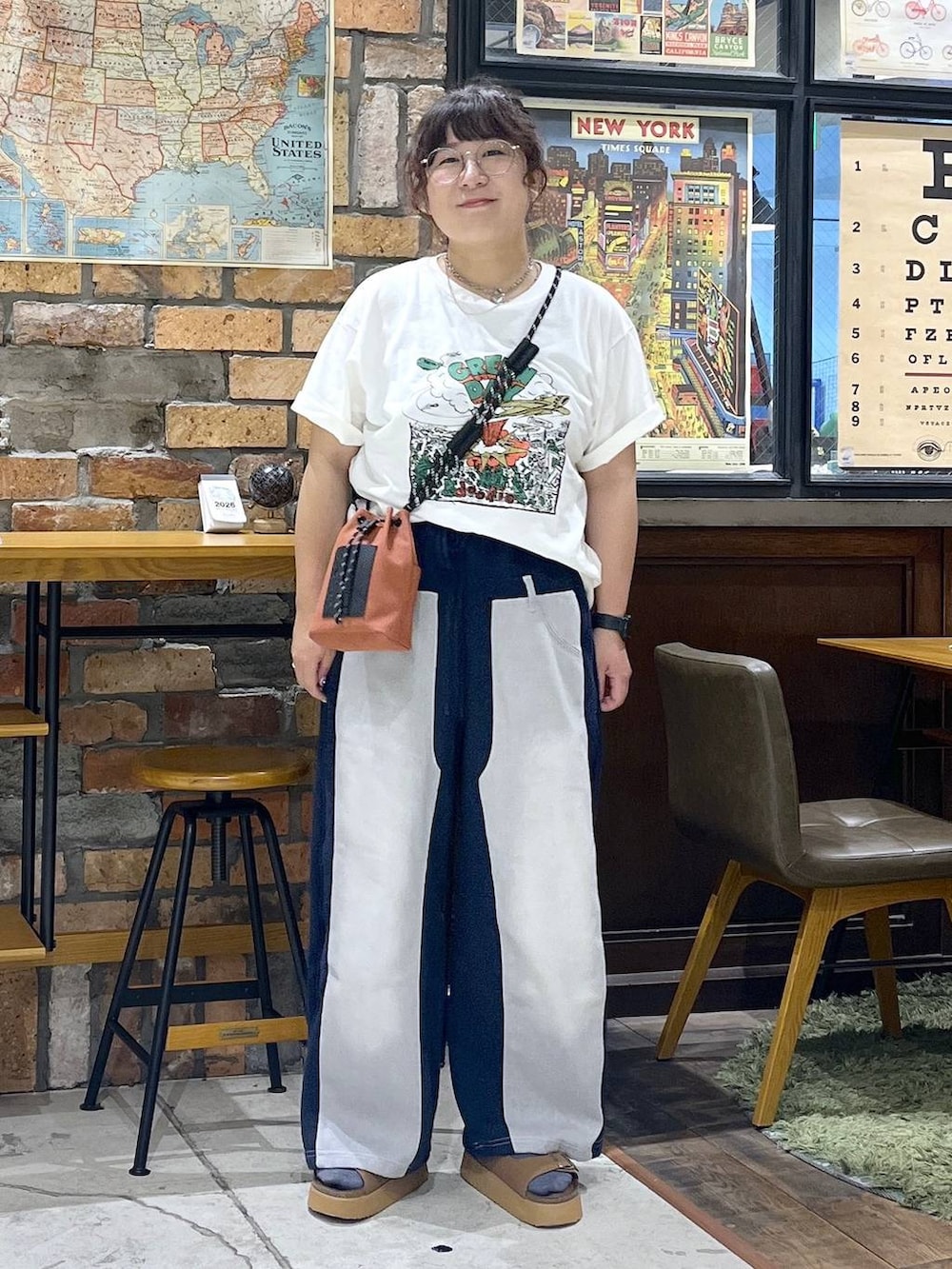オレンジ系のショルダーバッグ、ブルー系のデニムパンツ、ブラウン系のサンダルを着用したレディースの夏コーディネートの6枚目の写真