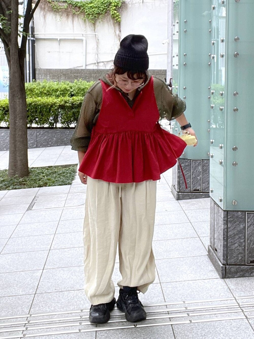 ベージュ系のその他パンツ、ブラック系のキャミソール、レッド系のベストを着用したレディースの夏コーディネートの6枚目の写真