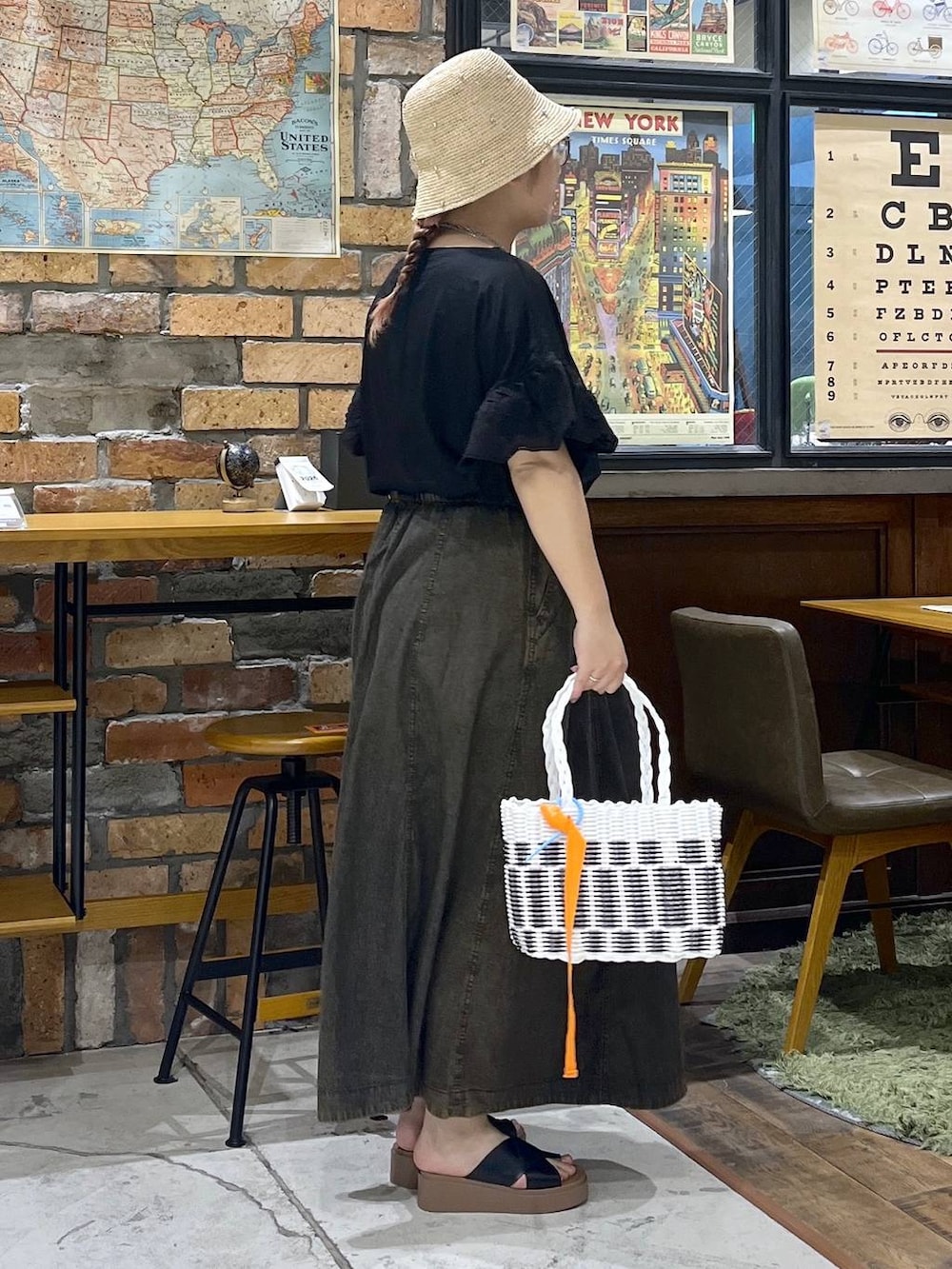 ブラック系のサンダル、ブラウン系のスカート、その他のかごバッグを着用したレディースの夏コーディネートの5枚目の写真
