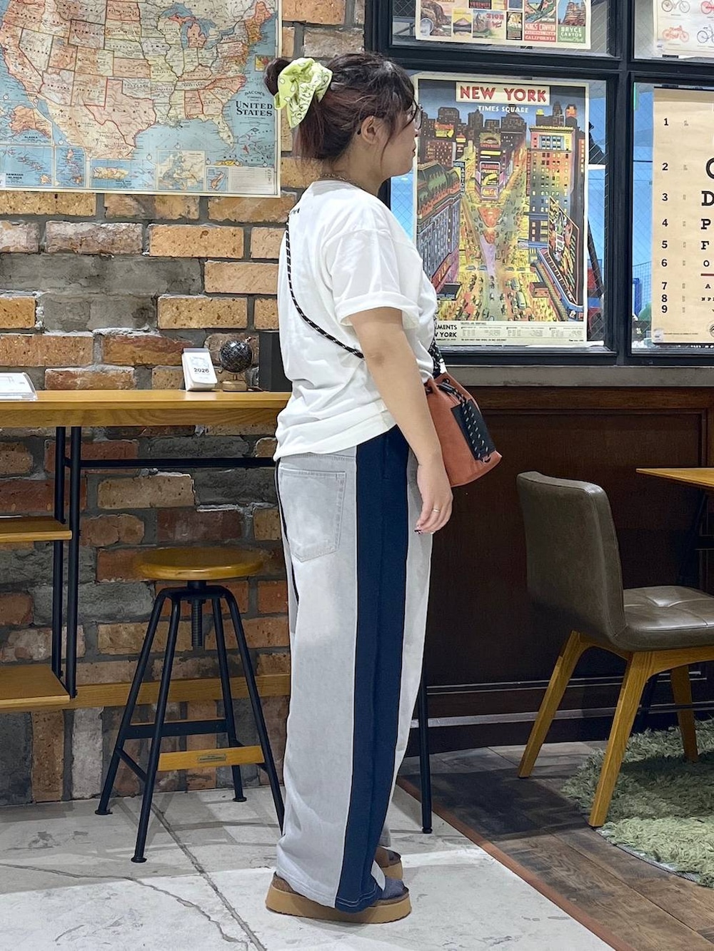 オレンジ系のショルダーバッグ、ブルー系のデニムパンツ、ブラウン系のサンダルを着用したレディースの夏コーディネートの5枚目の写真