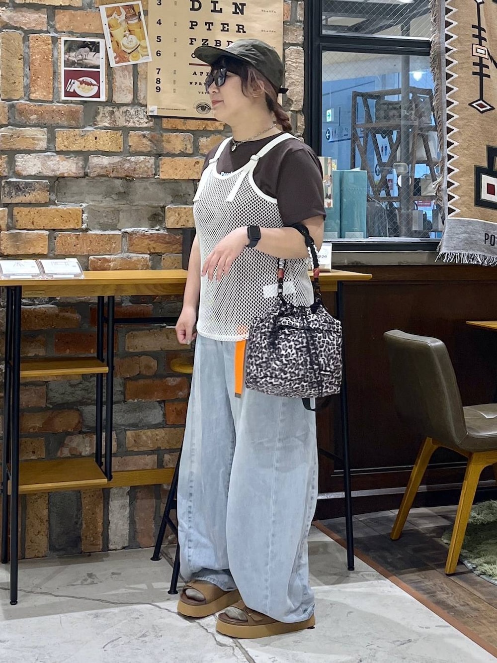 ホワイト系のタンクトップ、ブラウン系のTシャツ/カットソー、ブルー系のデニムパンツを着用したレディースの夏コーディネートの4枚目の写真