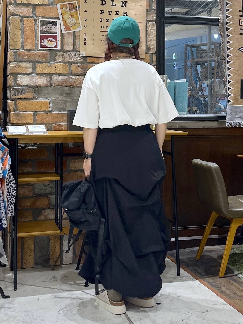 ベージュ系のサンダル、ホワイト系のTシャツ/カットソー、ブラック系のバックパック/リュックを着用したレディースの夏コーディネートの4枚目の写真