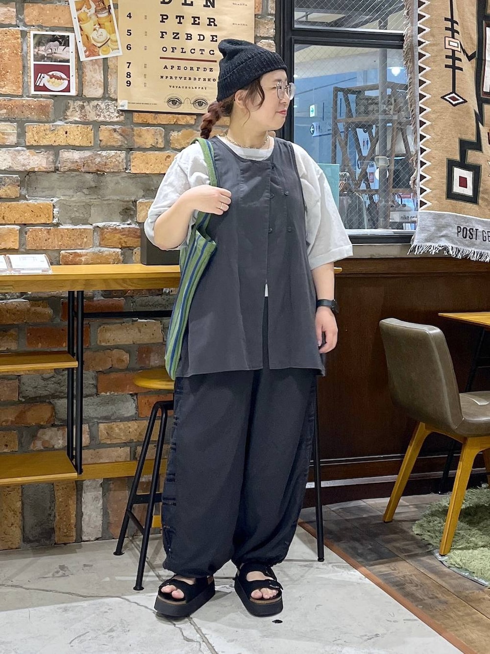ブラック系のベスト、ブラック系のその他パンツ、ブラック系のサンダルを着用したレディースの夏コーディネートの7枚目の写真