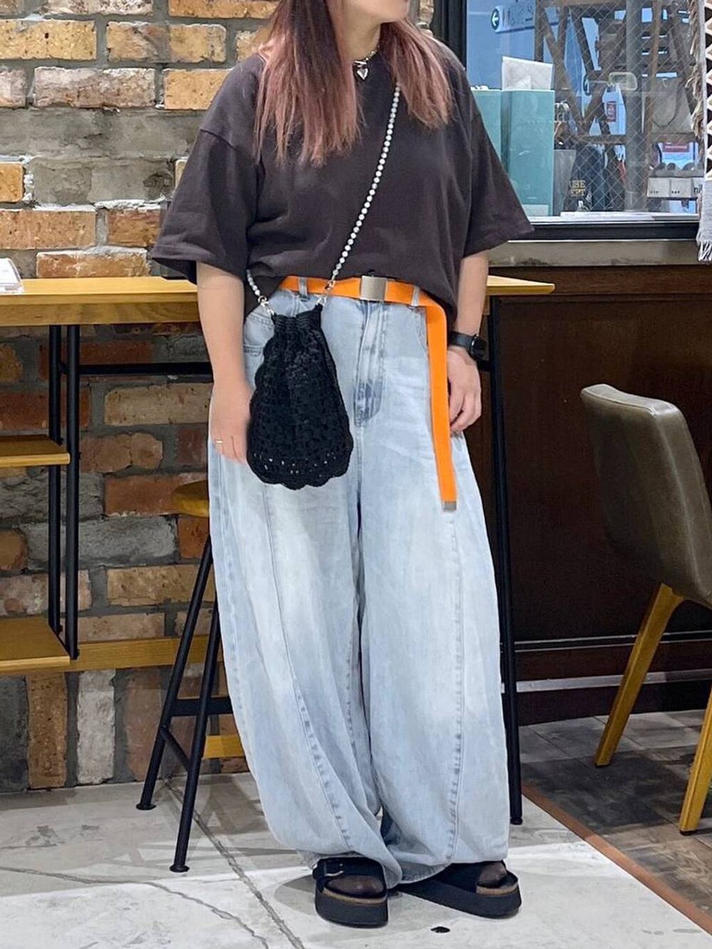 ブルー系のデニムパンツ、ブラウン系のTシャツ/カットソー、ブラック系のサンダルを着用したレディースの夏コーディネートの2枚目の写真