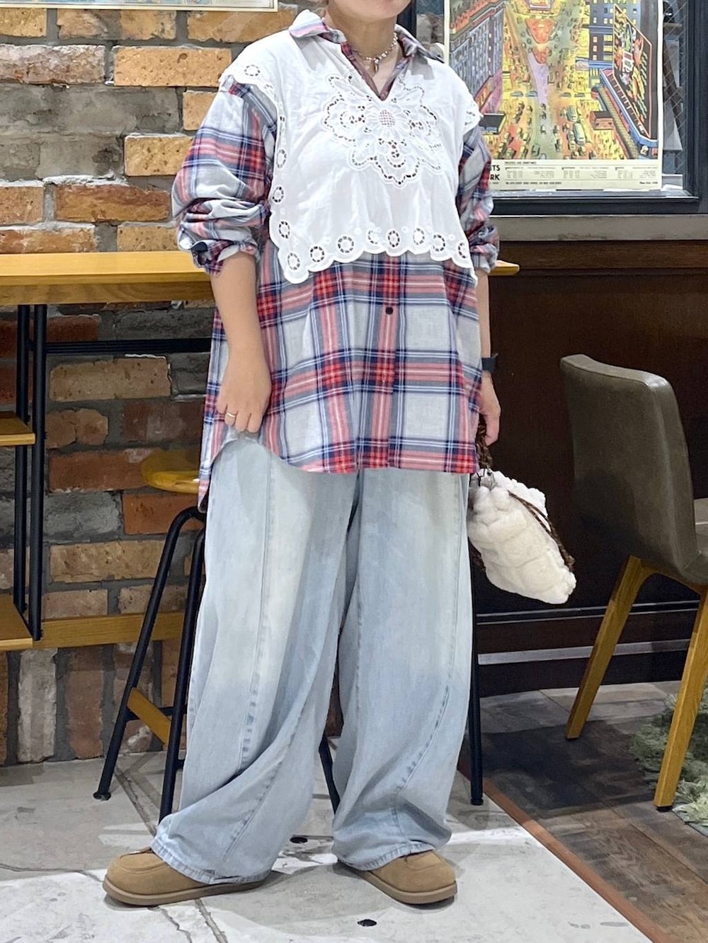 ホワイト系のベスト、ブルー系のデニムパンツ、イエロー系のモカシン/デッキシューズを着用したレディースの秋コーディネートの2枚目の写真