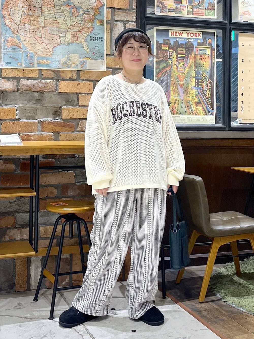 グリーン系のショルダーバッグ、ベージュ系のニット/セーター、ブラック系のスニーカーを着用したレディースの秋コーディネートの9枚目の写真