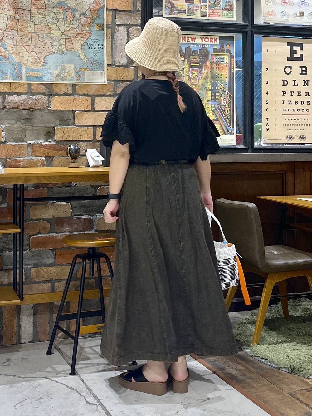 ブラック系のサンダル、ブラウン系のスカート、その他のかごバッグを着用したレディースの夏コーディネートの4枚目の写真
