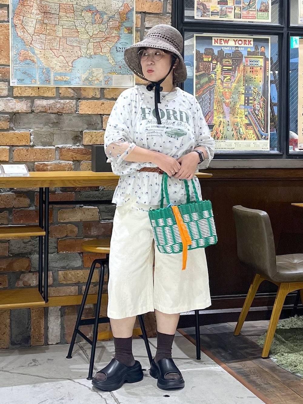 ブラック系のサンダル、ベージュ系のTシャツ/カットソー、グリーン系のかごバッグを着用したレディースの夏コーディネートの7枚目の写真