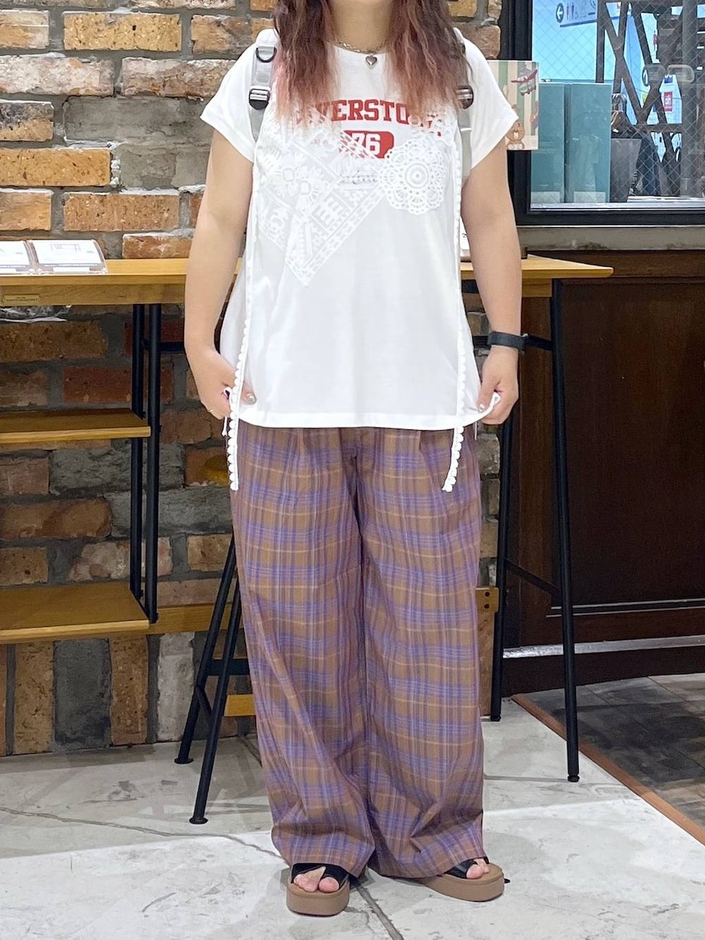 ブラック系のサンダル、ホワイト系のTシャツ/カットソー、グレー系のバックパック/リュックを着用したレディースの夏コーディネートの2枚目の写真