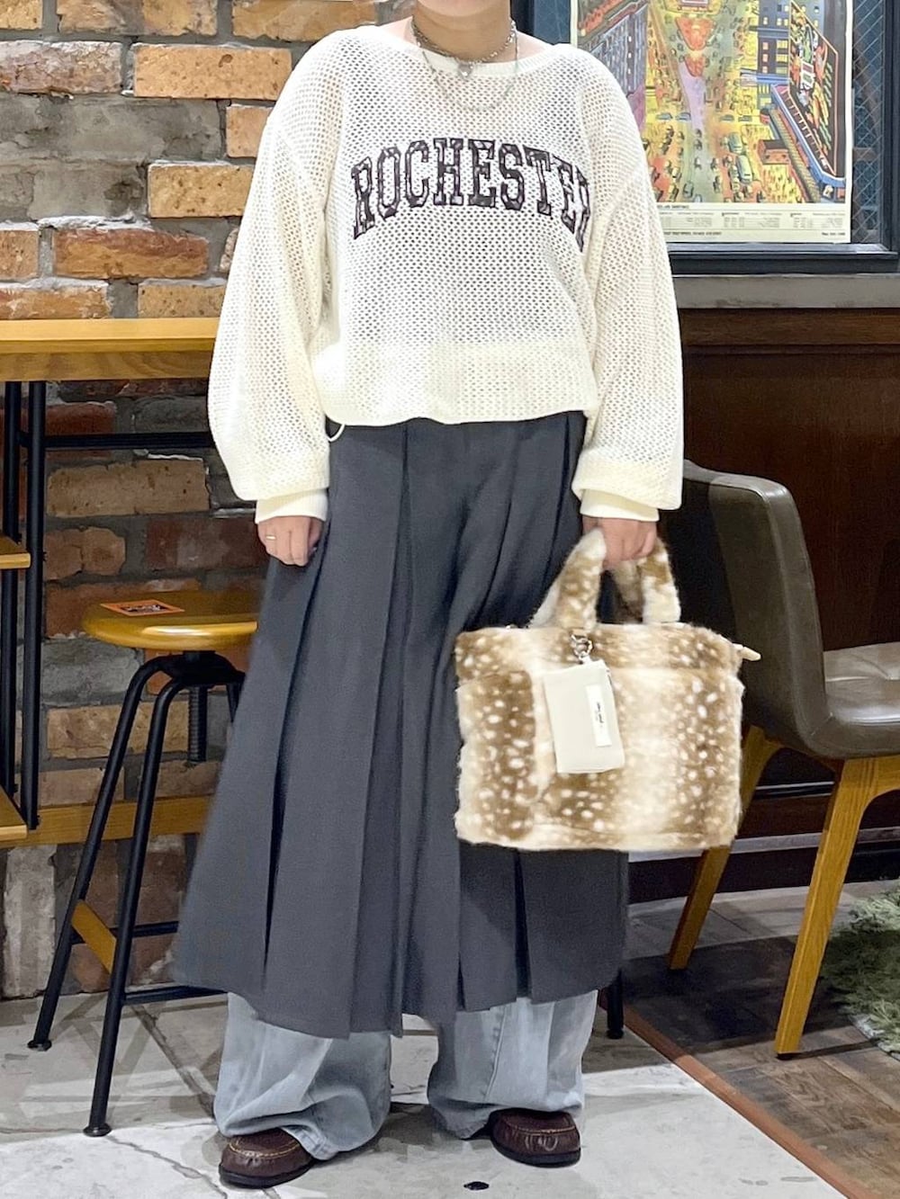 ブラウン系のローファー、ブルー系のデニムパンツ、ベージュ系のニット/セーターを着用したレディースの秋コーディネートの2枚目の写真