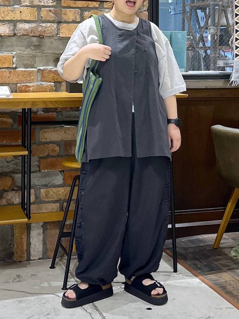 ブラック系のベスト、ブラック系のその他パンツ、ブラック系のサンダルを着用したレディースの夏コーディネートの2枚目の写真