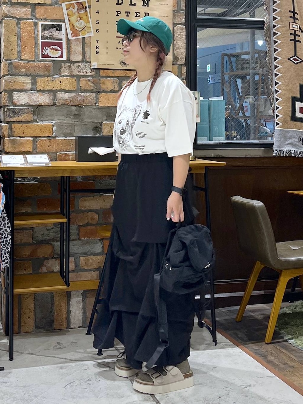 ベージュ系のサンダル、ホワイト系のTシャツ/カットソー、ブラック系のバックパック/リュックを着用したレディースの夏コーディネートの3枚目の写真