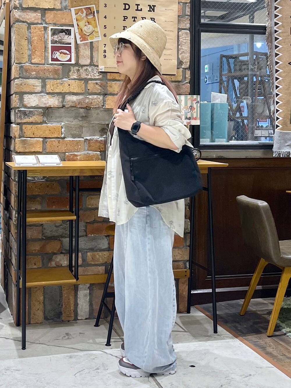 ブルー系のデニムパンツ、その他のスニーカー、ブラック系のトートバッグを着用したレディースの夏コーディネートの4枚目の写真