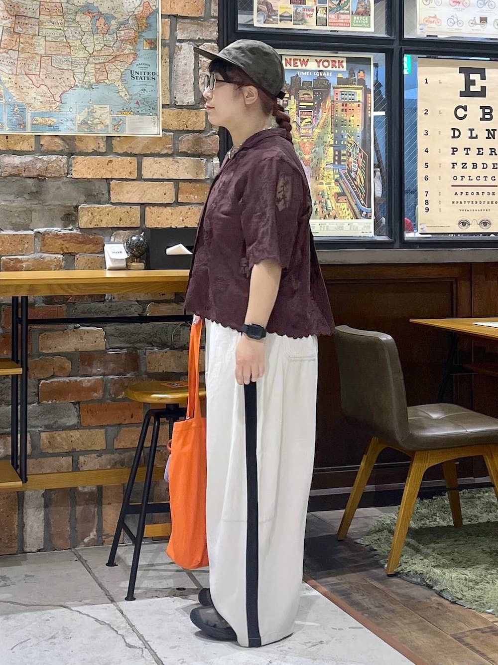 ブラウン系のその他パンツ、ブラウン系のシャツ/ブラウス、レッド系のトートバッグを着用したレディースの夏コーディネートの3枚目の写真