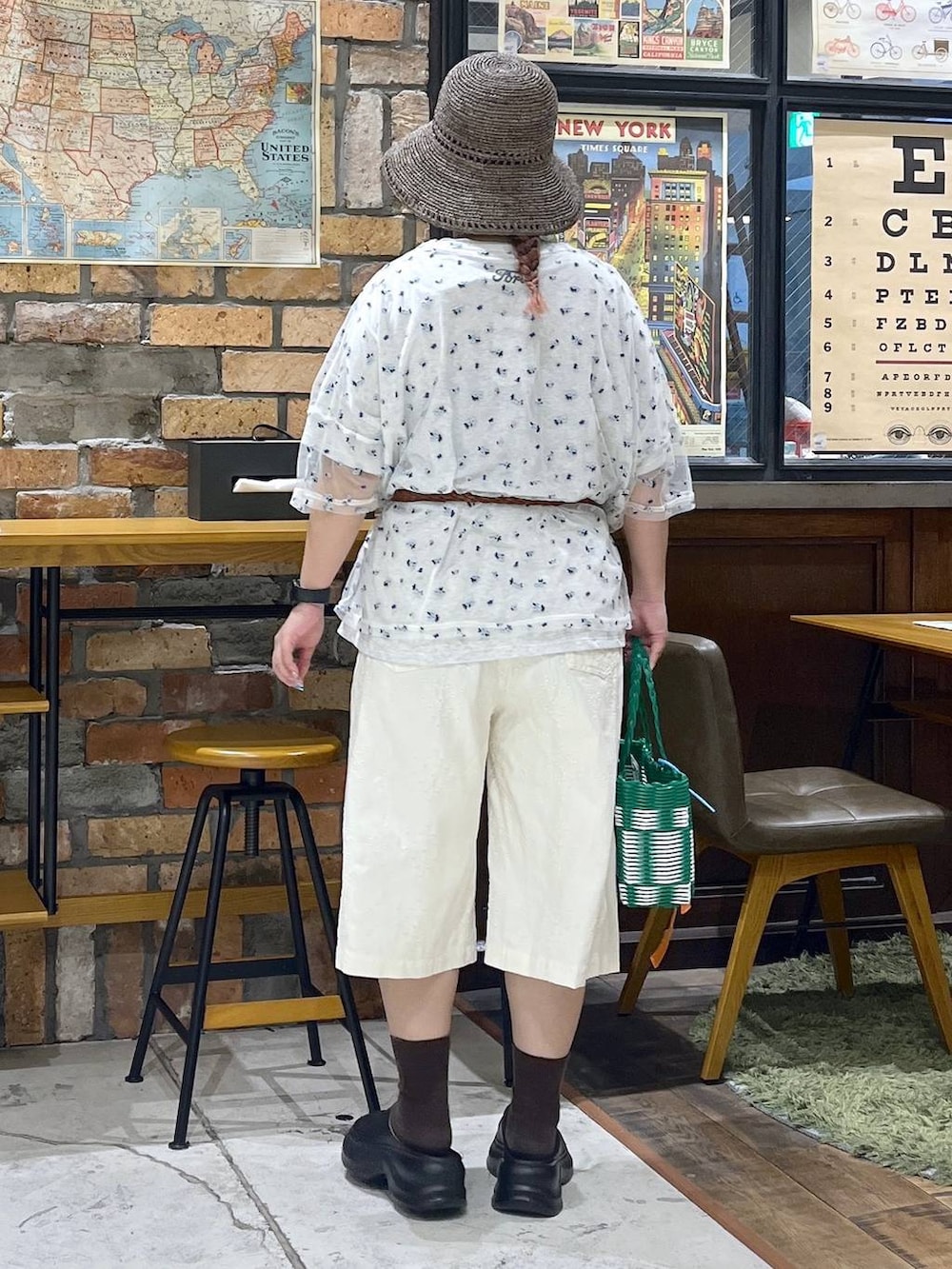 ブラック系のサンダル、ベージュ系のTシャツ/カットソー、グリーン系のかごバッグを着用したレディースの夏コーディネートの5枚目の写真
