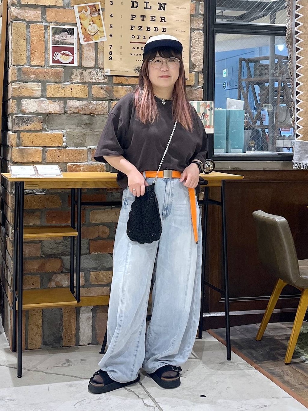 ブルー系のデニムパンツ、ブラウン系のTシャツ/カットソー、ブラック系のサンダルを着用したレディースの夏コーディネートの8枚目の写真