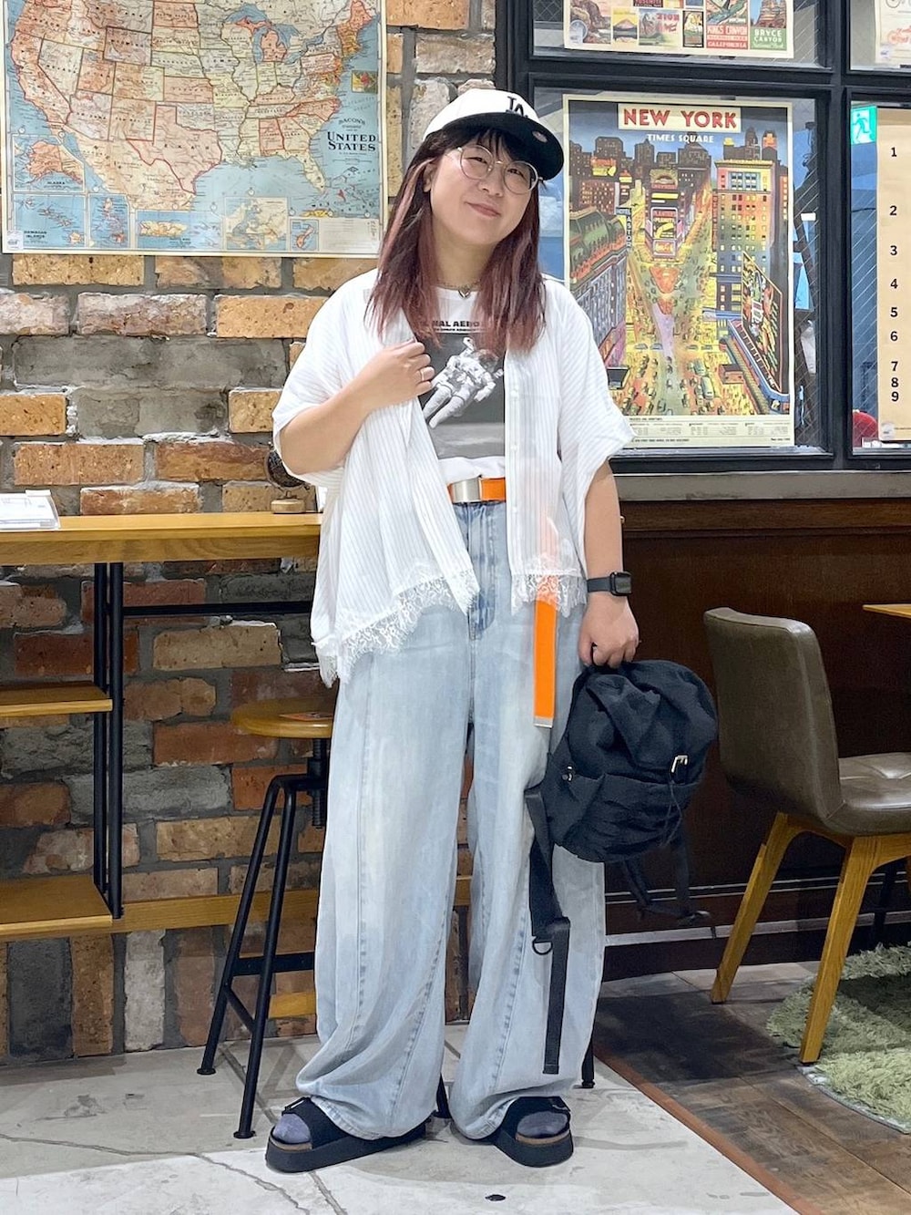 ブルー系のデニムパンツ、ブラック系のサンダル、ブラック系のバックパック/リュックを着用したレディースの夏コーディネートの6枚目の写真