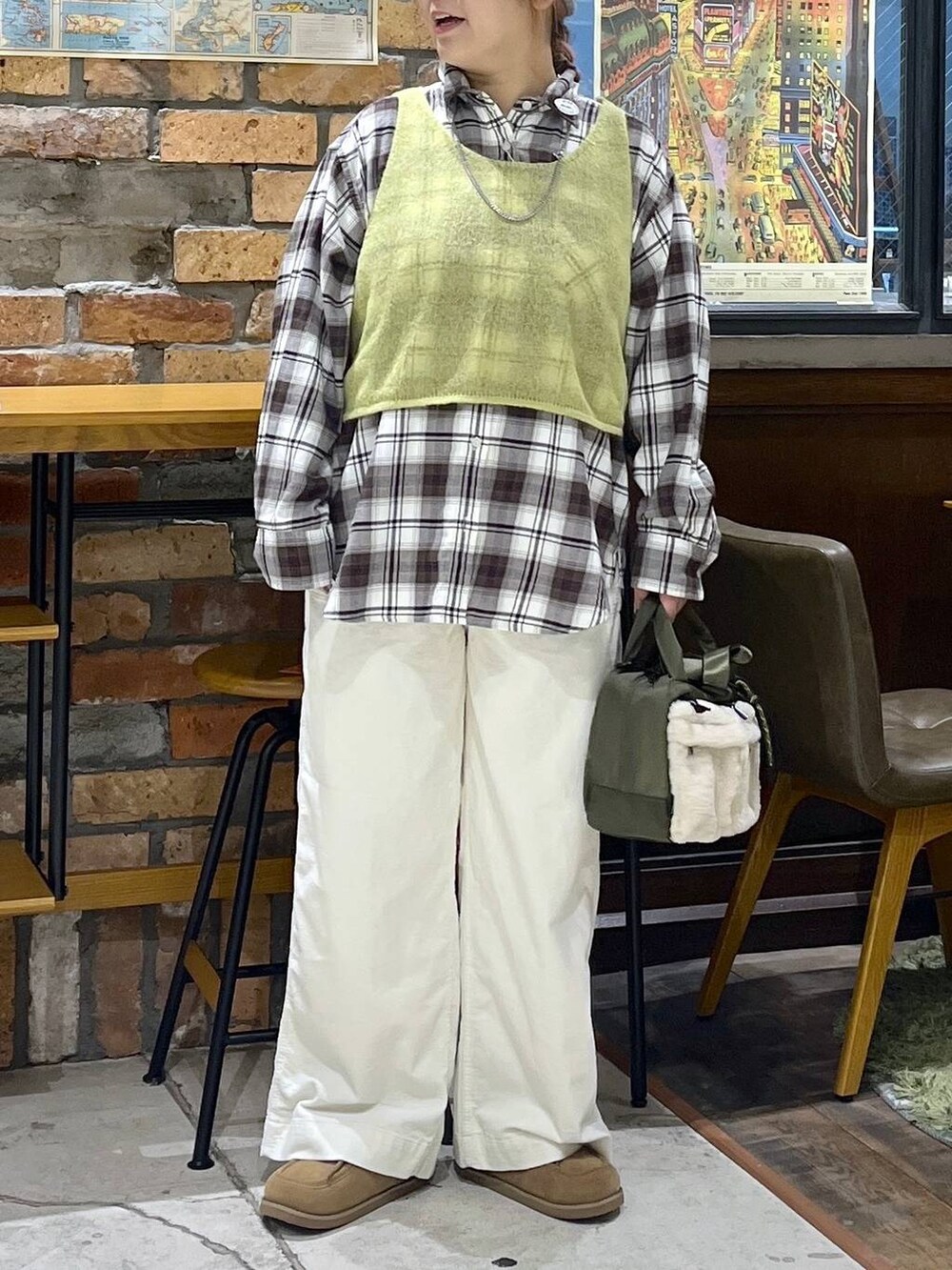 グレー系のチュニック、イエロー系のモカシン/デッキシューズ、グリーン系のショルダーバッグを着用したレディースの秋コーディネートの2枚目の写真