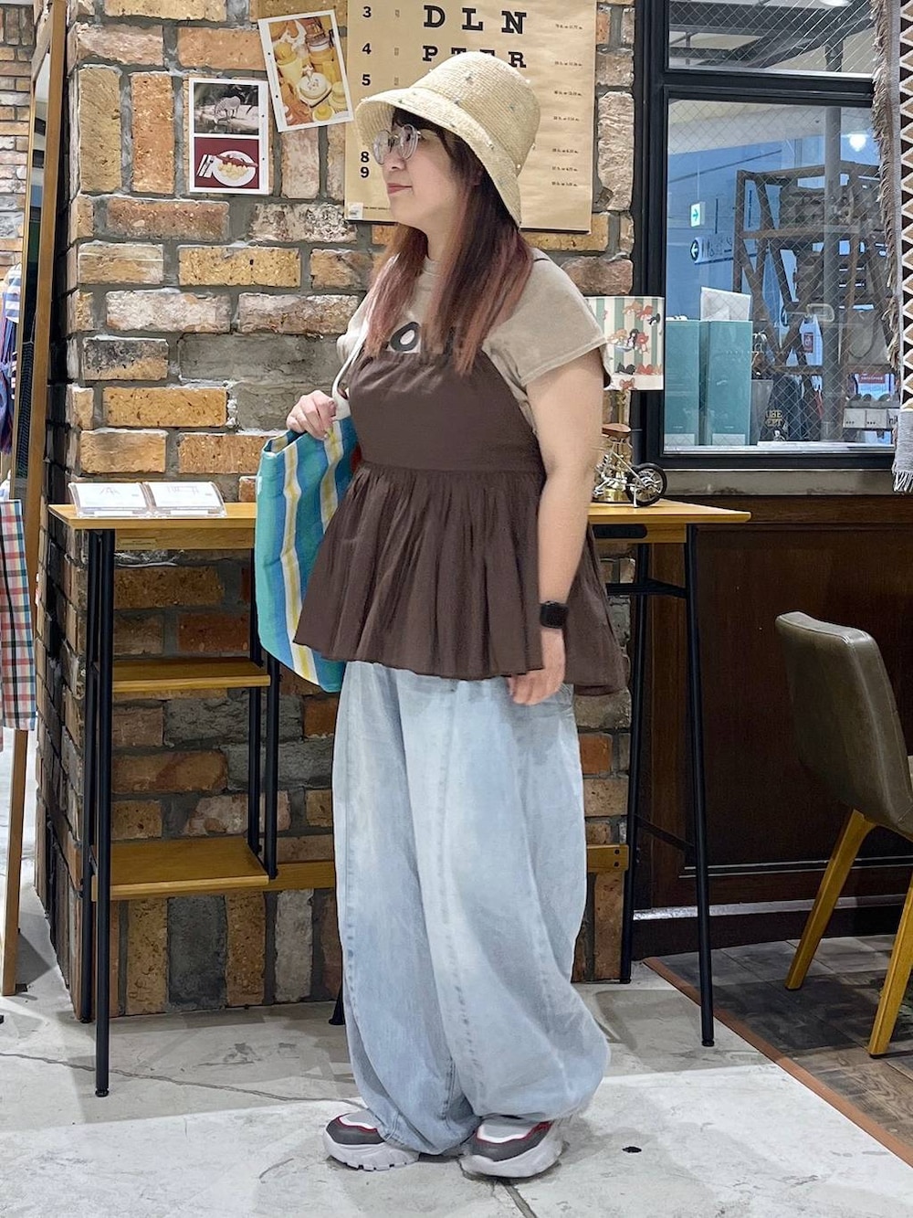 ブルー系のデニムパンツ、その他のスニーカー、レッド系のトートバッグを着用したレディースの夏コーディネートの4枚目の写真