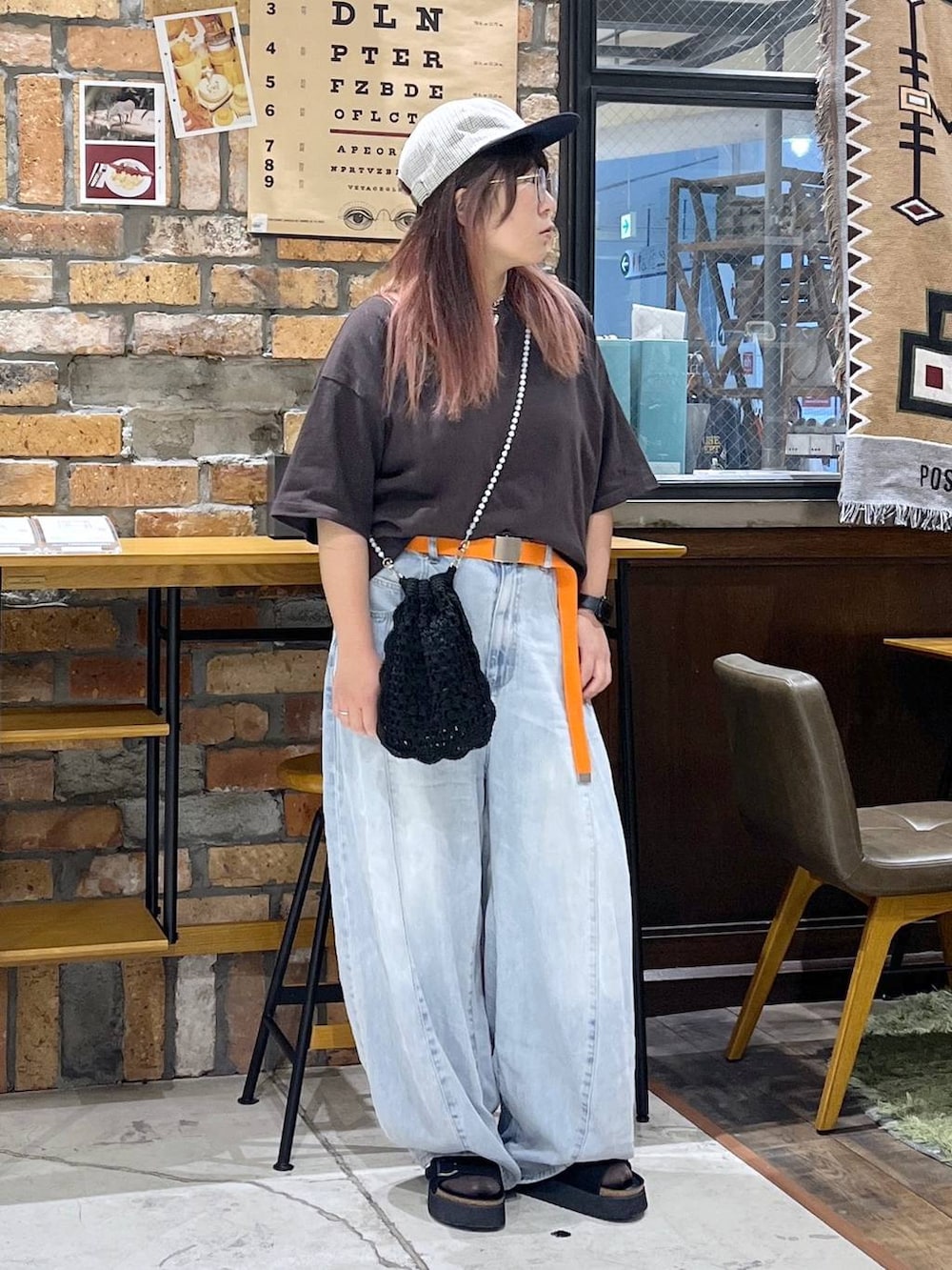 ブルー系のデニムパンツ、ブラウン系のTシャツ/カットソー、ブラック系のサンダルを着用したレディースの夏コーディネートの3枚目の写真