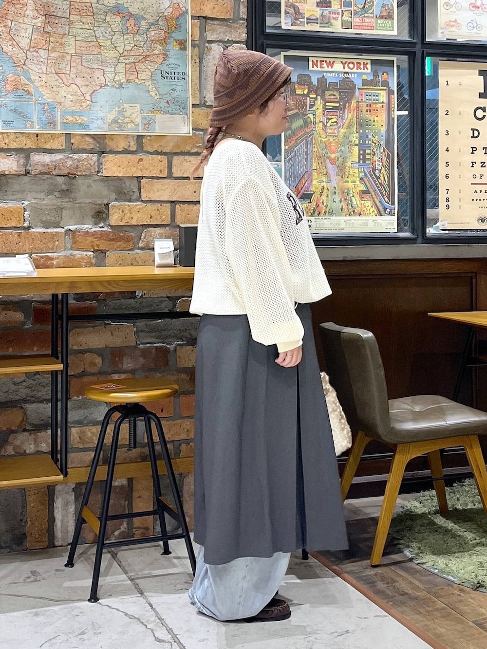 ブラウン系のローファー、ブルー系のデニムパンツ、ベージュ系のニット/セーターを着用したレディースの秋コーディネートの5枚目の写真