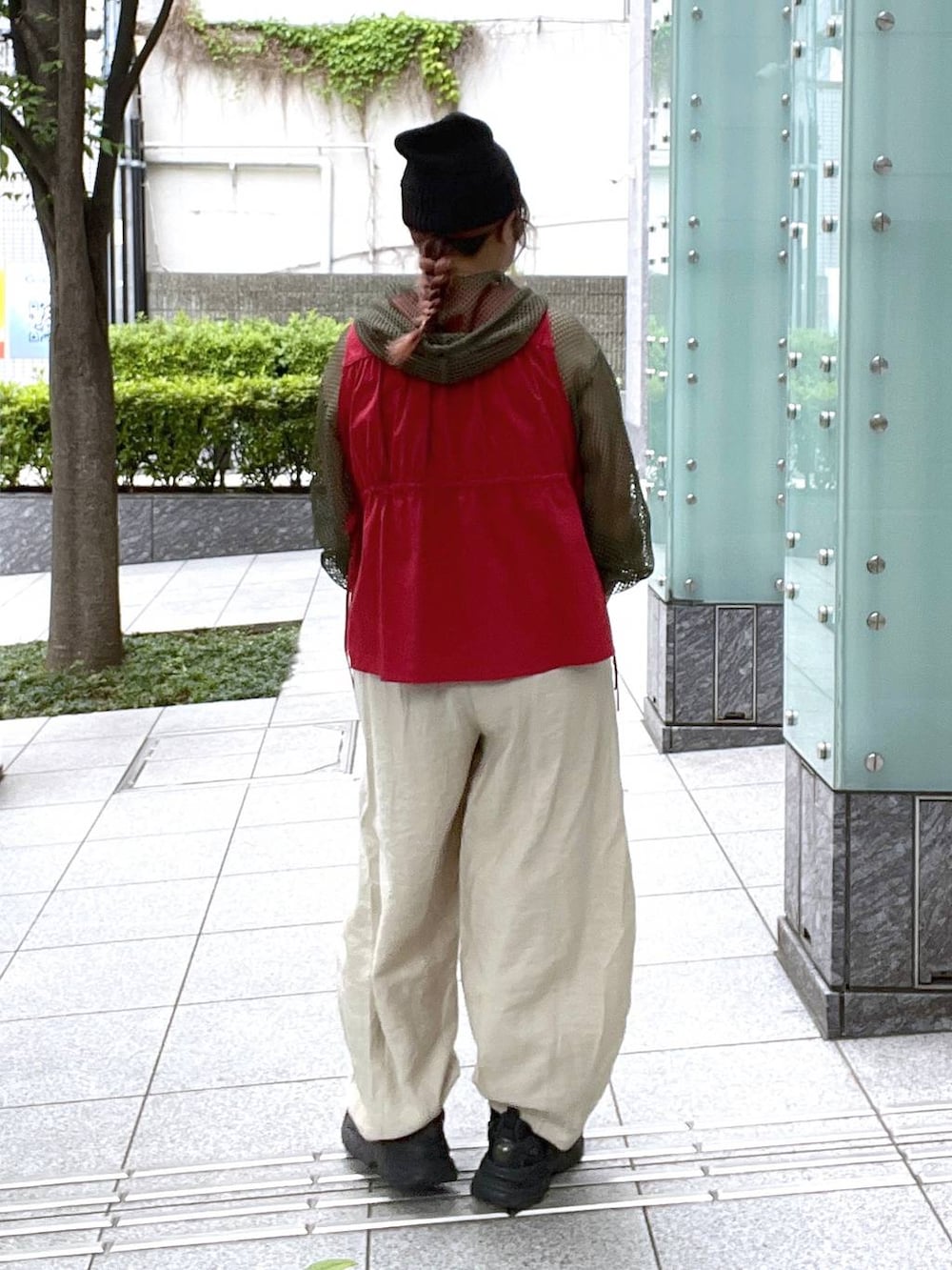 ベージュ系のその他パンツ、ブラック系のキャミソール、レッド系のベストを着用したレディースの夏コーディネートの5枚目の写真