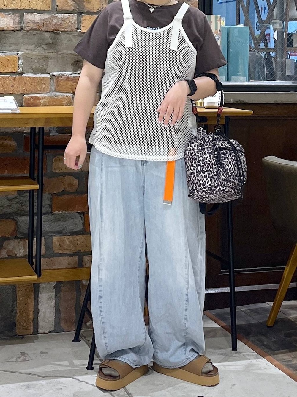 ホワイト系のタンクトップ、ブラウン系のTシャツ/カットソー、ブルー系のデニムパンツを着用したレディースの夏コーディネートの2枚目の写真