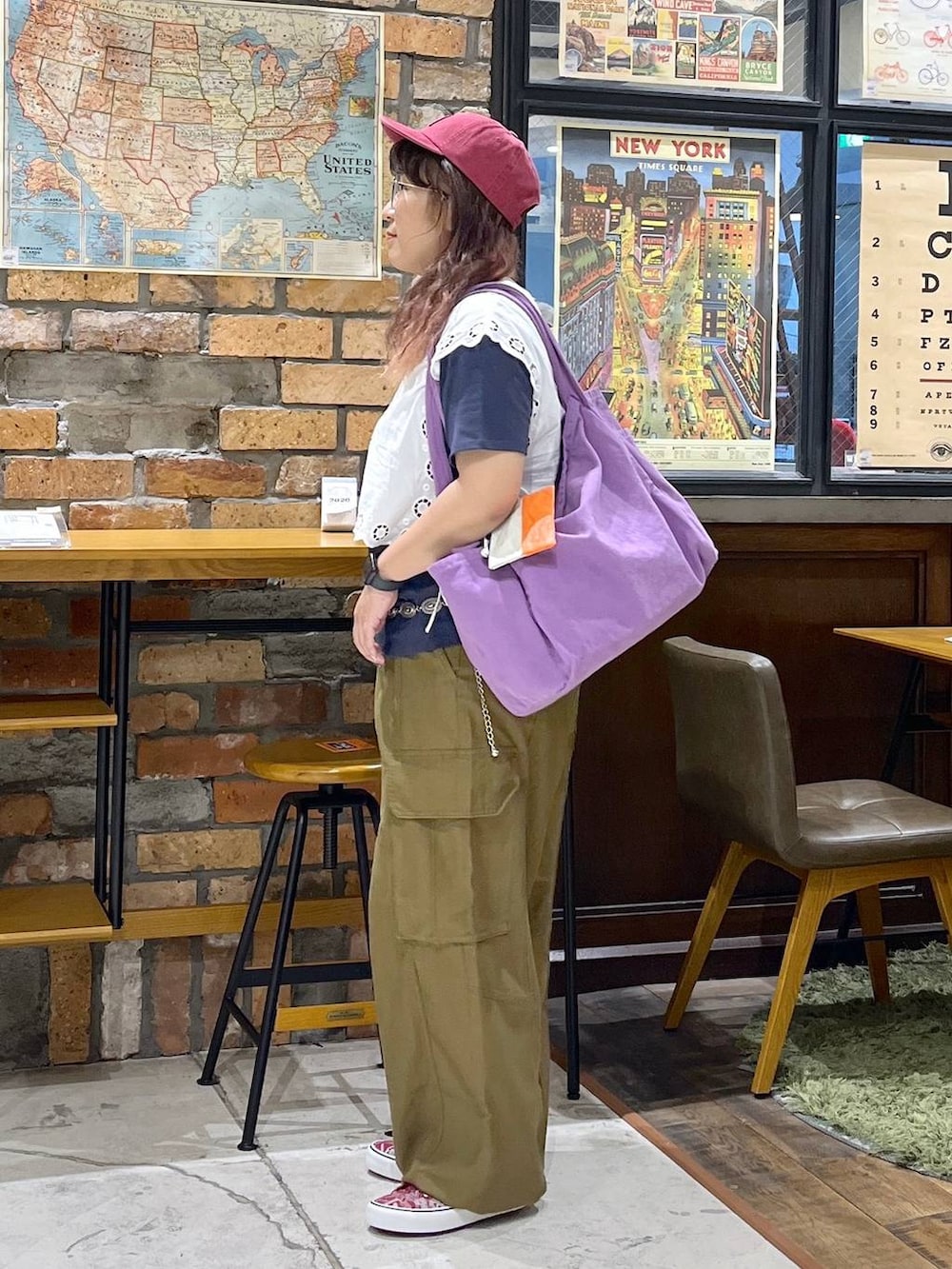 パープル系のトートバッグ、ホワイト系のベスト、ブルー系のTシャツ/カットソーを着用したレディースの夏コーディネートの4枚目の写真