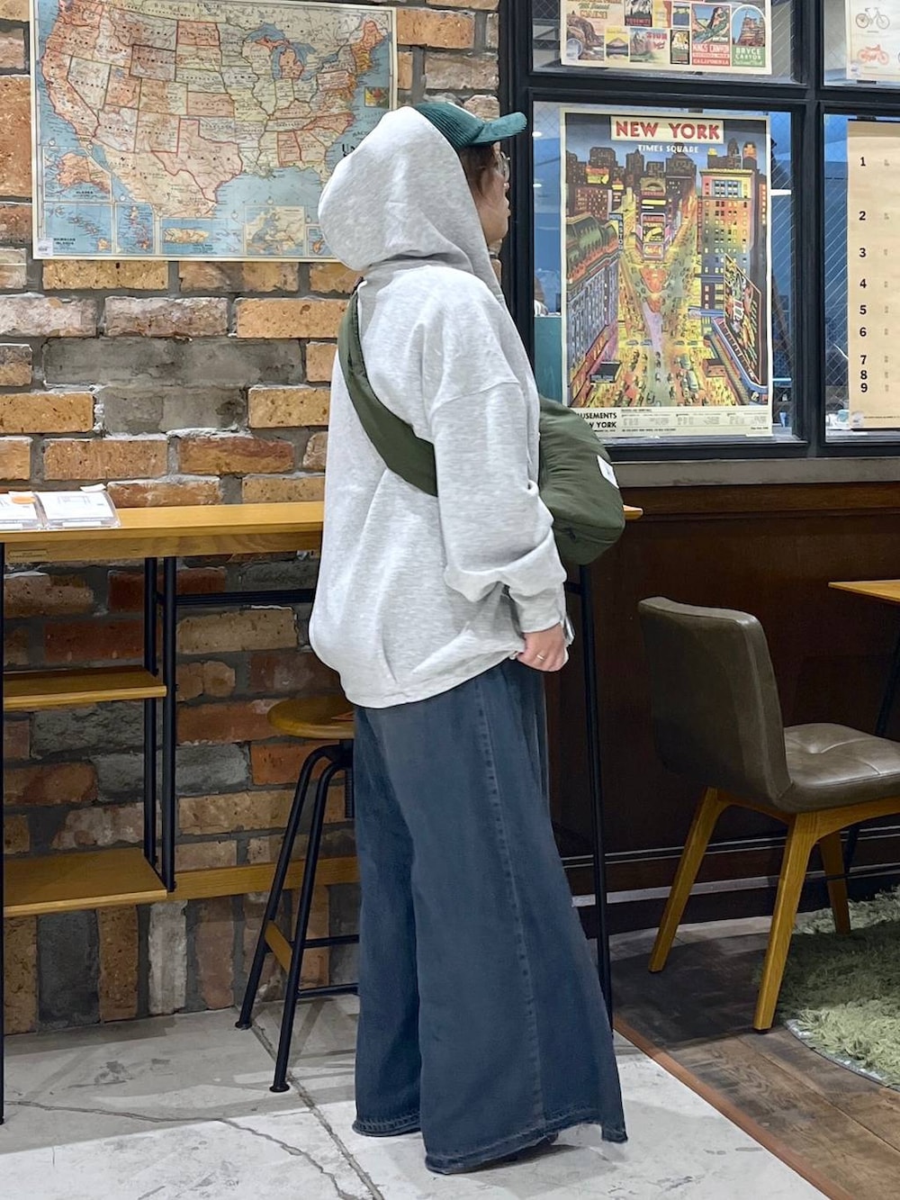 グレー系のパーカー、グリーン系のショルダーバッグ、イエロー系のモカシン/デッキシューズを着用したレディースの秋コーディネートの6枚目の写真