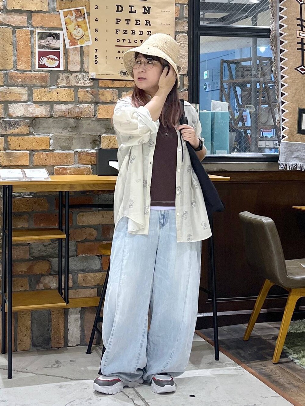 ブルー系のデニムパンツ、その他のスニーカー、ブラック系のトートバッグを着用したレディースの夏コーディネートの7枚目の写真