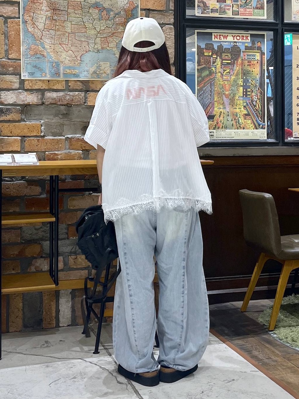ブルー系のデニムパンツ、ブラック系のサンダル、ブラック系のバックパック/リュックを着用したレディースの夏コーディネートの4枚目の写真