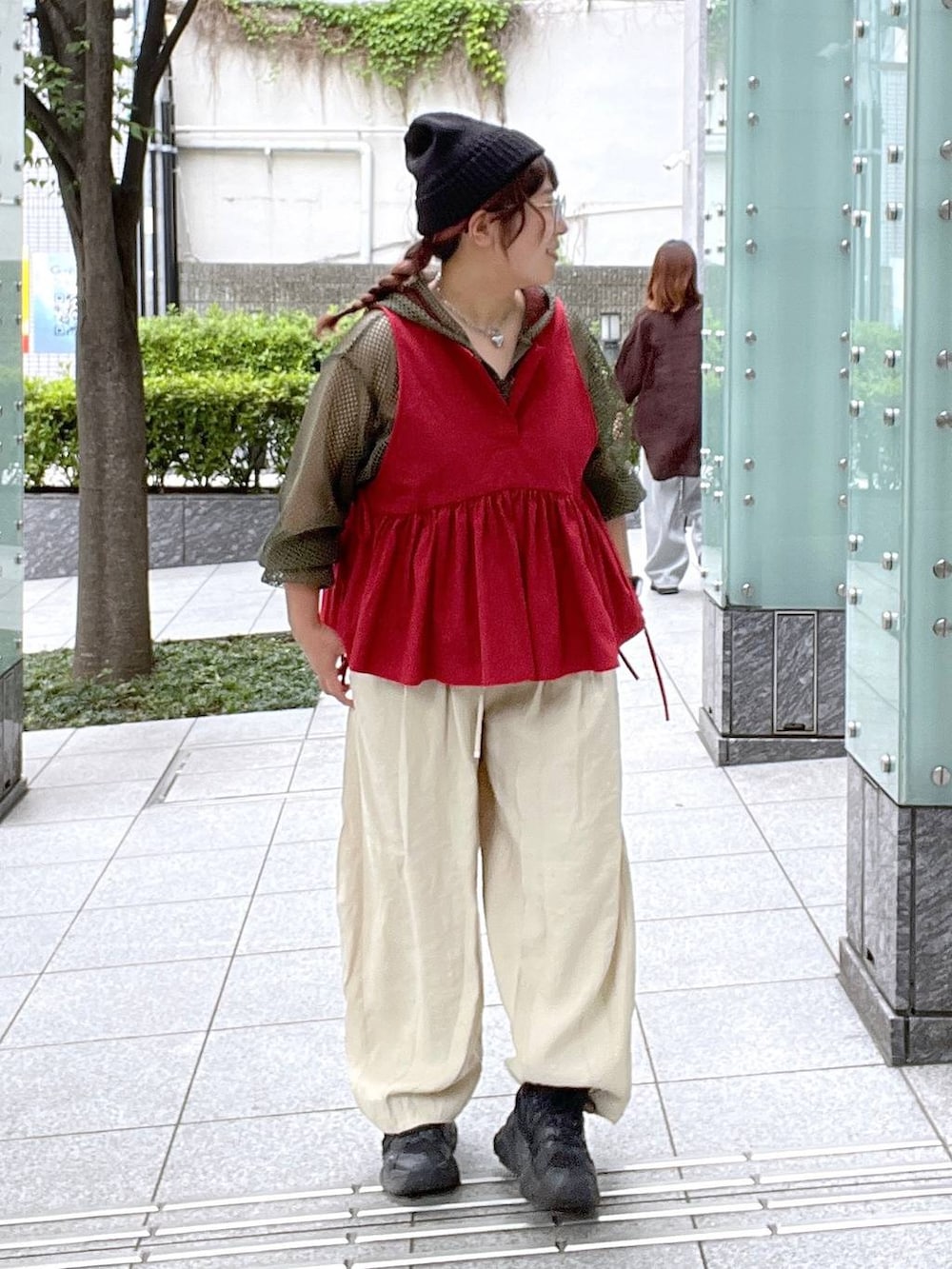 ベージュ系のその他パンツ、ブラック系のキャミソール、レッド系のベストを着用したレディースの夏コーディネートの3枚目の写真