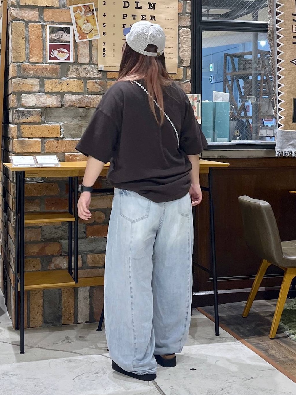 ブルー系のデニムパンツ、ブラウン系のTシャツ/カットソー、ブラック系のサンダルを着用したレディースの夏コーディネートの5枚目の写真