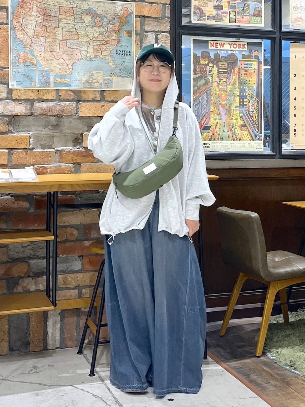 グレー系のパーカー、グリーン系のショルダーバッグ、イエロー系のモカシン/デッキシューズを着用したレディースの秋コーディネートの3枚目の写真