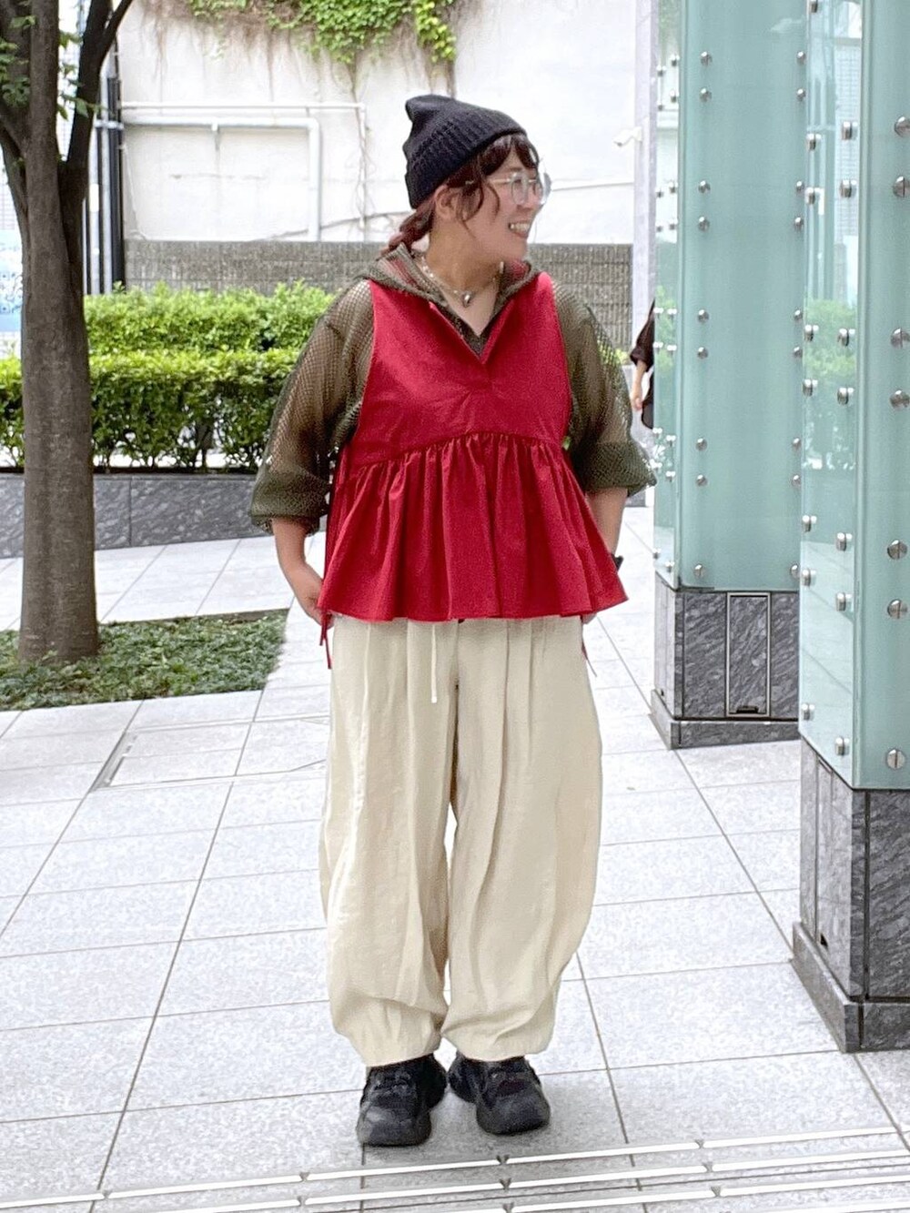 ベージュ系のその他パンツ、ブラック系のキャミソール、レッド系のベストを着用したレディースの夏コーディネートの7枚目の写真