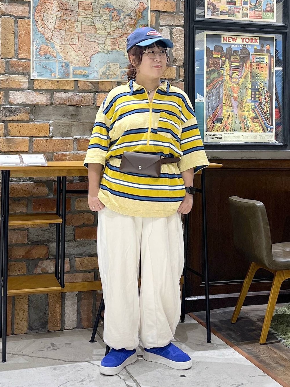 ベージュ系のデニムパンツ、イエロー系のTシャツ/カットソー、ブルー系のキャップを着用したレディースの夏コーディネートの3枚目の写真