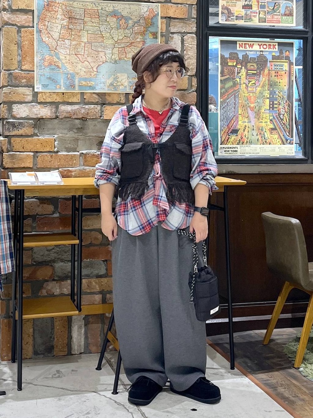 ブラウン系のベスト、レッド系のTシャツ/カットソー、ブラック系のモカシン/デッキシューズを着用したレディースの秋コーディネートの3枚目の写真