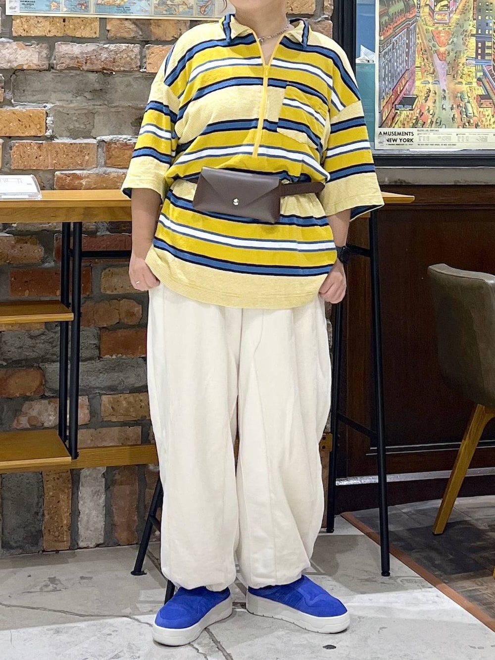 ベージュ系のデニムパンツ、イエロー系のTシャツ/カットソー、ブルー系のキャップを着用したレディースの夏コーディネートの2枚目の写真