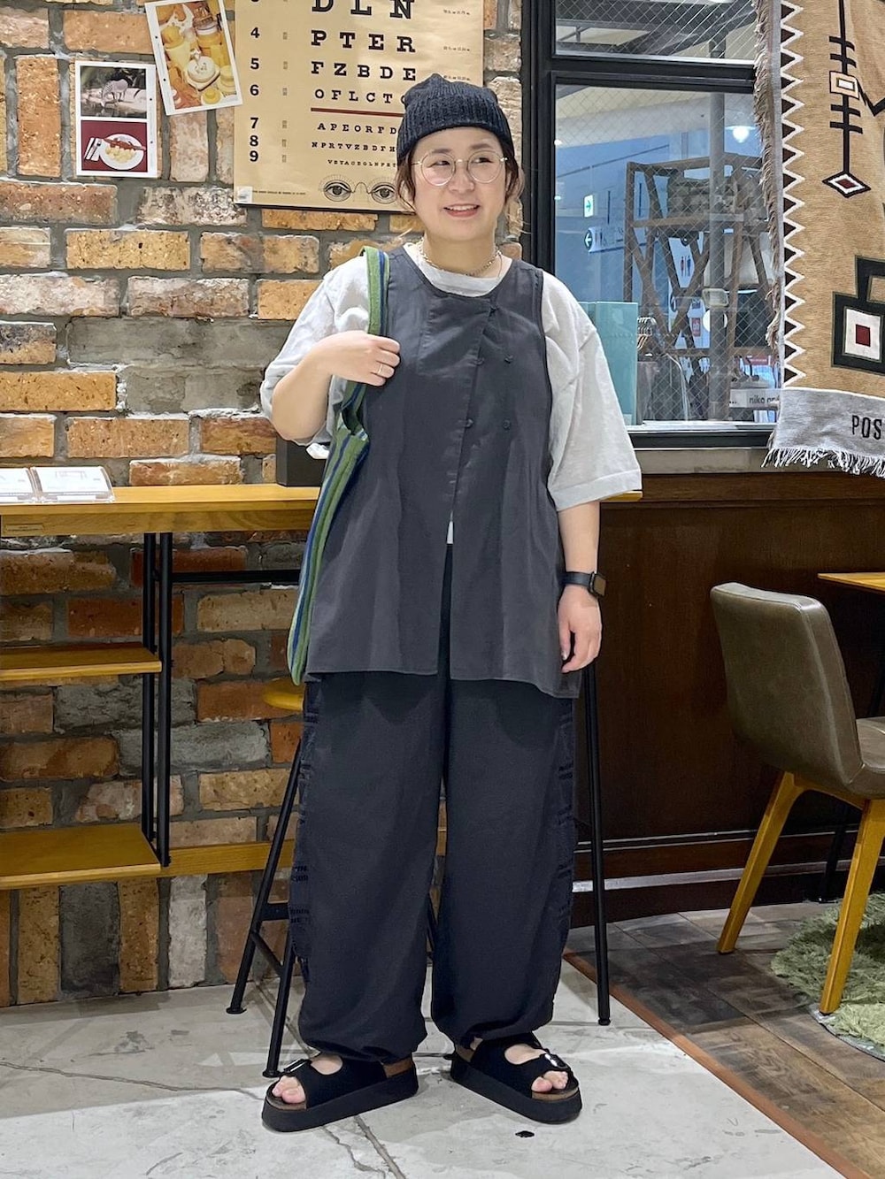 ブラック系のベスト、ブラック系のその他パンツ、ブラック系のサンダルを着用したレディースの夏コーディネートの9枚目の写真
