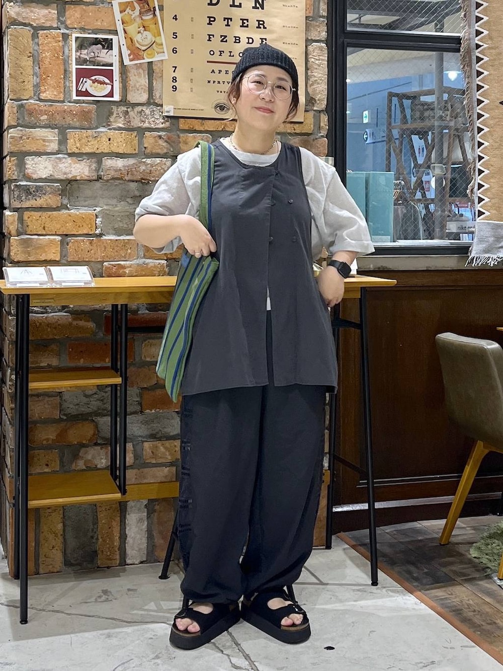ブラック系のベスト、ブラック系のその他パンツ、ブラック系のサンダルを着用したレディースの夏コーディネートの8枚目の写真