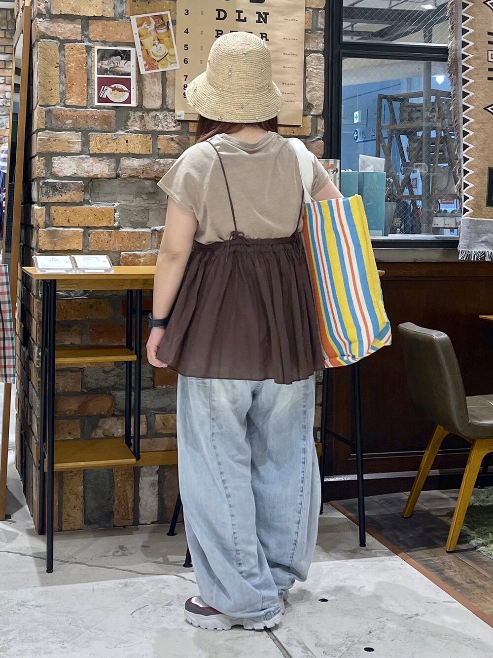 ブルー系のデニムパンツ、その他のスニーカー、レッド系のトートバッグを着用したレディースの夏コーディネートの5枚目の写真